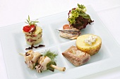 Four different fish dishes on a plate
