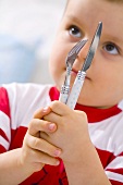 Little boy holding knife and fork