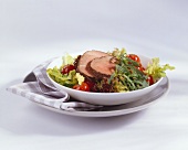 Marinated beef fillet on salad