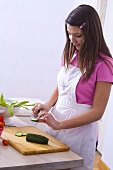 Girl cutting a cucumber