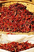 Dried chillies in baskets and sacks at a market