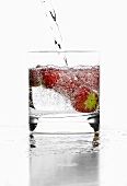 Mineral water in a glass, garnished with strawberries