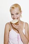 Young woman eating a slice of bread and butter