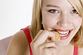 Young woman biting into a mini sandwich biscuit