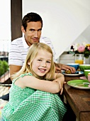 Tochter und Vater sitzen am Frühstückstisch