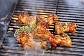 Chicken wings with rosemary on smoking barbecue