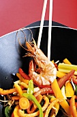 Vegetables and prawn cooked in wok with chopping sticks