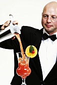 Bartender pouring cocktail into glass, portrait