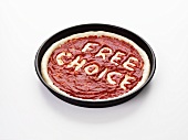 Pizzateig mit der Aufschrift 'Free choice' in Tomatensauce