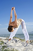 South Africa, Cape Town, Young woman exercising on beach