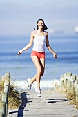 Young woman using skipping rope