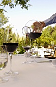 Waiter pouring red wine in glass