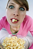 Young woman eating popcorn, portrait, elevated view