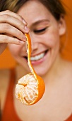 Young Woman holding tangerine, close-up