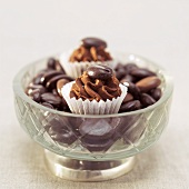 Espresso pralines with coffee beans in bowl, close-up