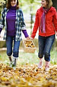 Mother and daughter carrying basket of chanterelles