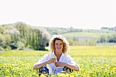 Woman sitting in a field of dandelions