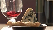 Pouring red wine behind savoury straw and blue cheese