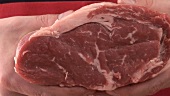 Ein Stück frisches Rindfleisch und Schürze mit Aufschrift
