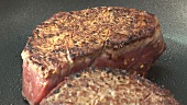 Frying fillet steaks in a frying pan (detail)