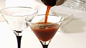 Cocktail in ein Cocktailglas einschenken