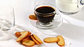 A cup of coffee with biscuits