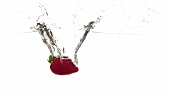 A strawberry falling into water