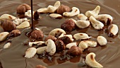 Pouring melted milk chocolate onto nuts