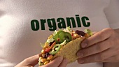 Hände halten Taco mit Gemüsefüllung