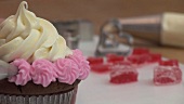 Decorating chocolate cupcake with pink buttercream