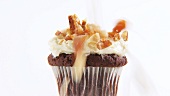 Chocolate muffin with cream, candied fruit and nuts