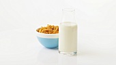 A bowl of cornflakes and a bottle of milk