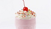 Milkshake with cream, sprinkles and cocktail cherry (detail)