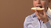 Junge Frau isst eine Bagelhälfte mit Cream Cheese