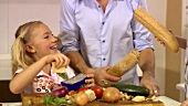 Little boy hitting his sister on the head with a baguette