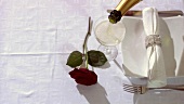 Elegant gedeckter Tisch mit roter Rose und Champagner