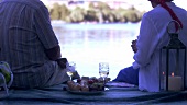 Mature couple picnicking on landing stage