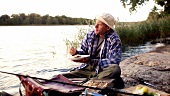 Mann isst den frisch gefangenen und gegrillten Fisch