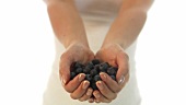 Young woman holding fresh blueberries