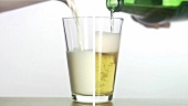 Milch und Bier in ein Glas gießen