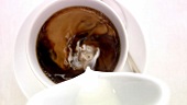 Pouring a cup of coffee, adding sugar and milk