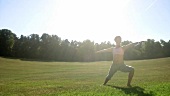 Frau macht Yogaübungen im Park