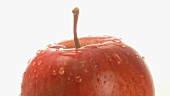 A rotating apple with drops of water