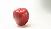 A rotating apple with drops of water