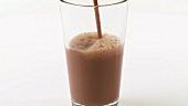 Pouring chocolate milk into a glass