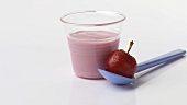 Cherry yoghurt in pot and a cherry on spoon