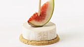 Soft cheese and fig on cocktail stick on cracker