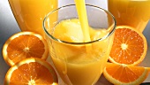 Orangensaft in ein Glas gießen