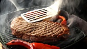 Strips of red pepper and steak in a grill frying pan