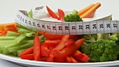 Platter of raw vegetables with dip and tape measure